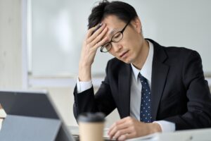 ストレスだらけで仕事中に悩む男性