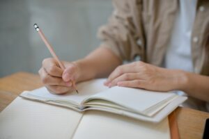 ノートにお願いを書く若い女性
